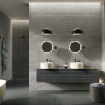 Dunkles Badezimmer mit zwei Waschbecken und runden Spiegeln